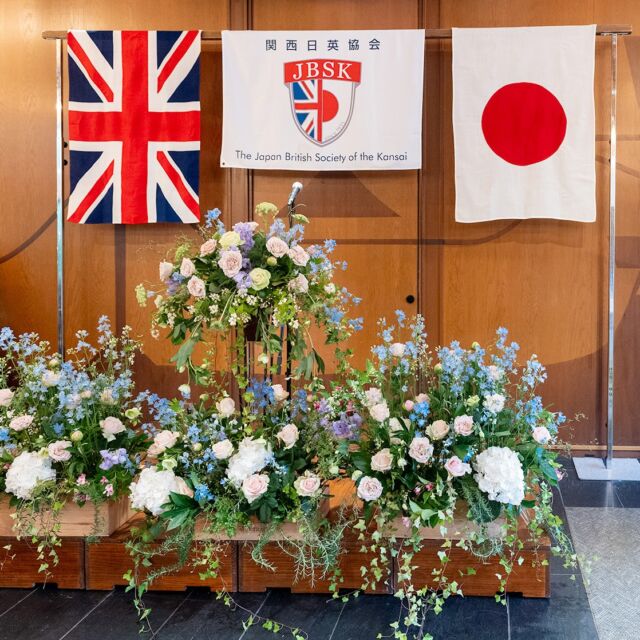 【関西日英協会　イギリス・チャールズ3世　国王陛下誕生日祝賀パーティー装花を担当】
昨日6月2日に、イギリスのチャールズ国王陛下の誕生パーティ―に参列し、会場装花をフラワーワークスジャパンの理事とともに担当してまいりました。毎年ご依頼いただき、今年で12回目になります。
会場は大阪のザ・ガーデンオリエンタルで、G20が行われた迎賓館のなかにあるパーティー会場でした。
1月に新任されたブライスイギリス総領事は、ガーデニングを学ばれているそうでご挨拶させていただいた時に、お花をお渡しするととても喜ばれておられました。
関西日英協会の会長様にもご挨拶させていただきました。いつもお世話になっている事務局の皆様にも感謝申し上げます。
どんな場所でも花がつないでくれるご縁があります。仲間とともに関わらせていただけることで、より嬉しい気持ちでいっぱいになります。これからも花がつないでくれるご縁を大切に、人との繋がりを大切にしていきたいと思います。  #アトリエフィーズ
#フラワーワークスジャパン
#谷川文江
#イギリス
#フラワーアレンジメント